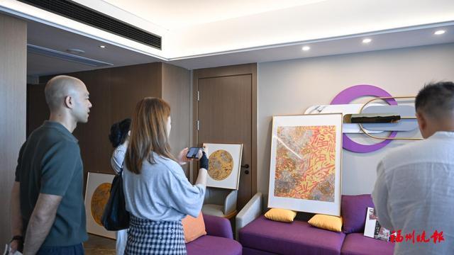 艺术爱好者在酒店客房内观看展览。