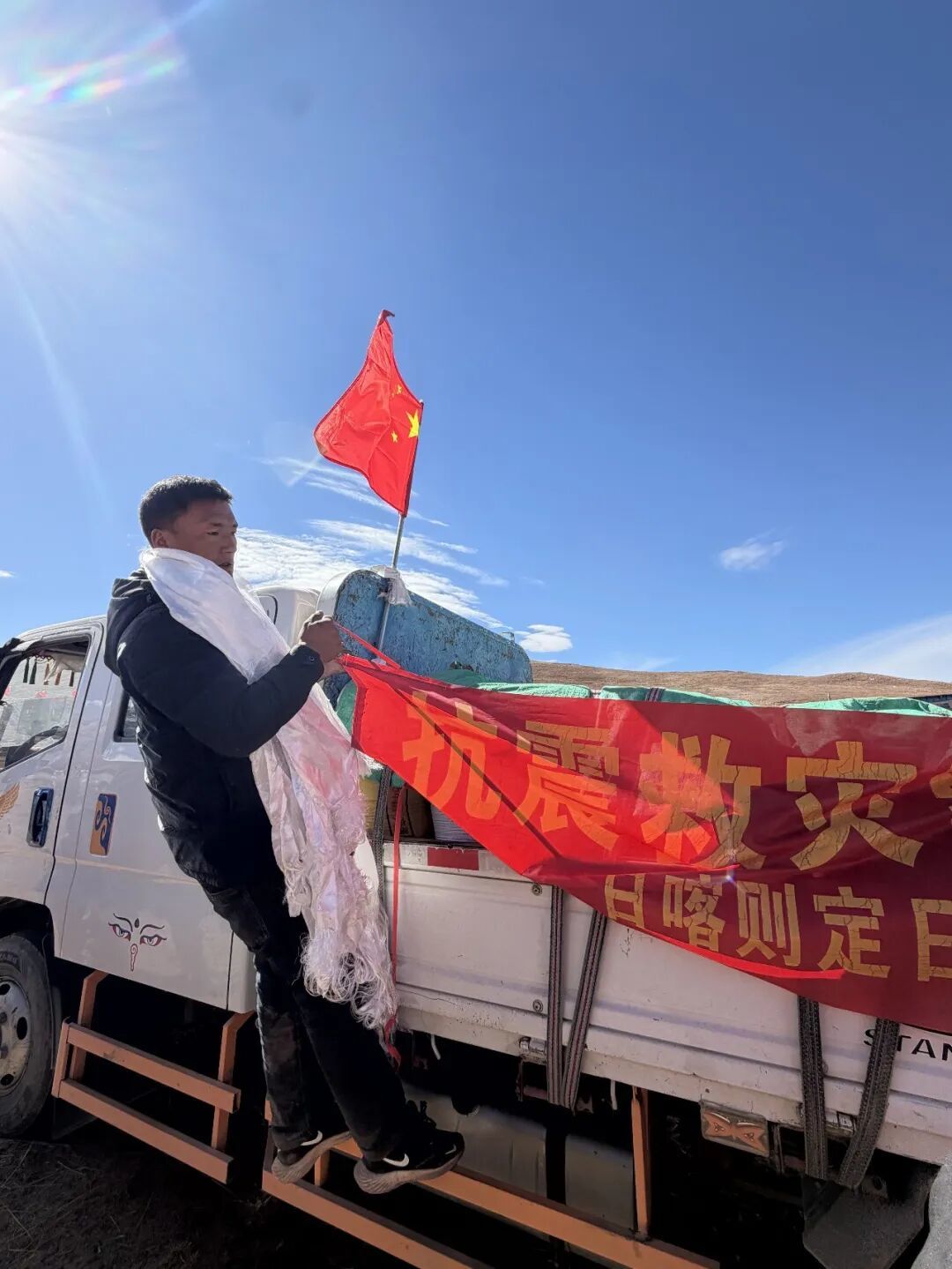 图为定日县长所乡强嘎村村民格桑平措停车后马上卸物资。记者 旦增旺姆 摄
