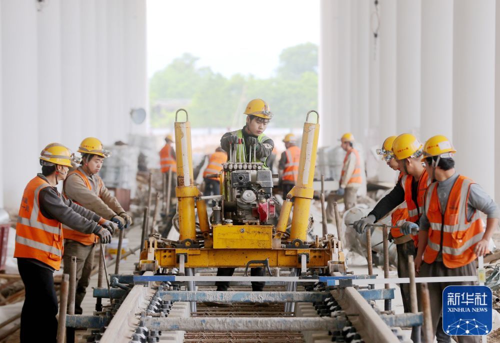 ↑ 5月3日，中铁十一局建设者在浙江省湖州市德清县杭德市域铁路舞阳车辆基地进行轨道组装起道作业。新华社发（谢尚国 摄）