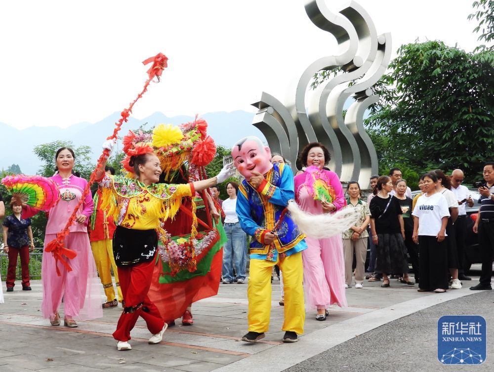 ↑ 6月17日,在四川省达州市渠县临巴镇凉桥村龙嬉谷农旅景区“我们的节日·端午”主题活动现场,民间艺人表演秧歌舞。新华社发(邓良奎摄)
