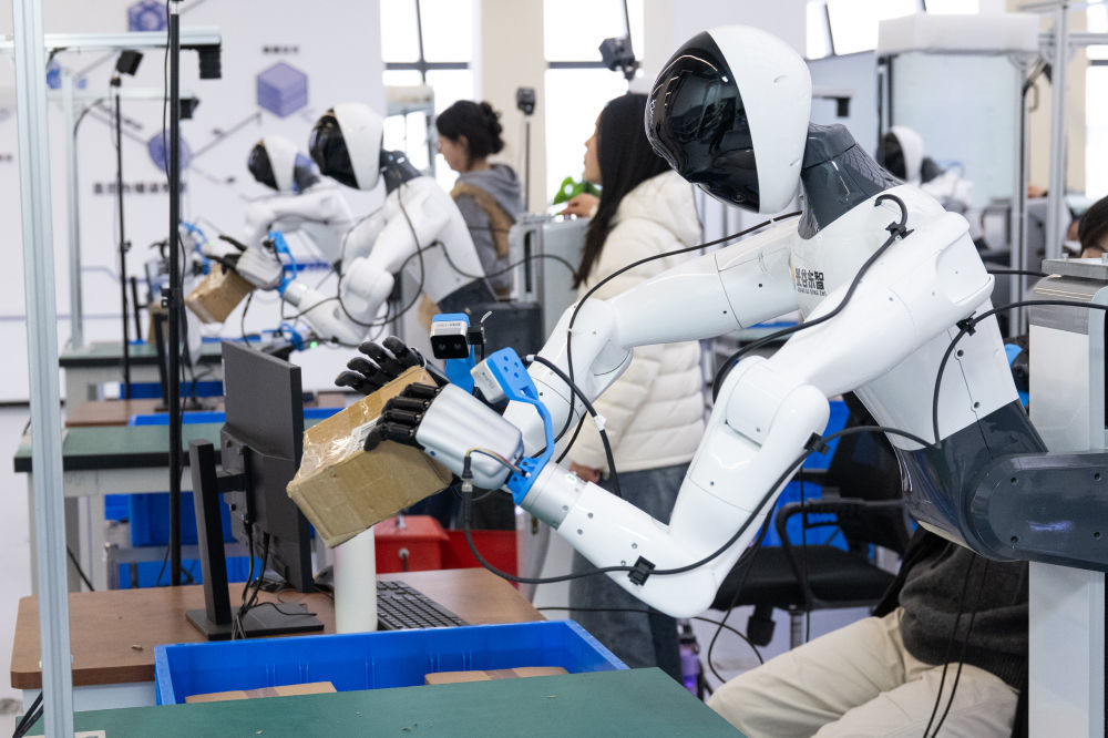 2025年12月4日,在湖北人形机器人创新中心,数据采集员操作人形机器人进行数据采集。新华社记者 肖艺九 摄