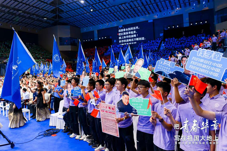 同学们手中举着的应援牌，上面都是一位位中国科学家的名字。主办方供图