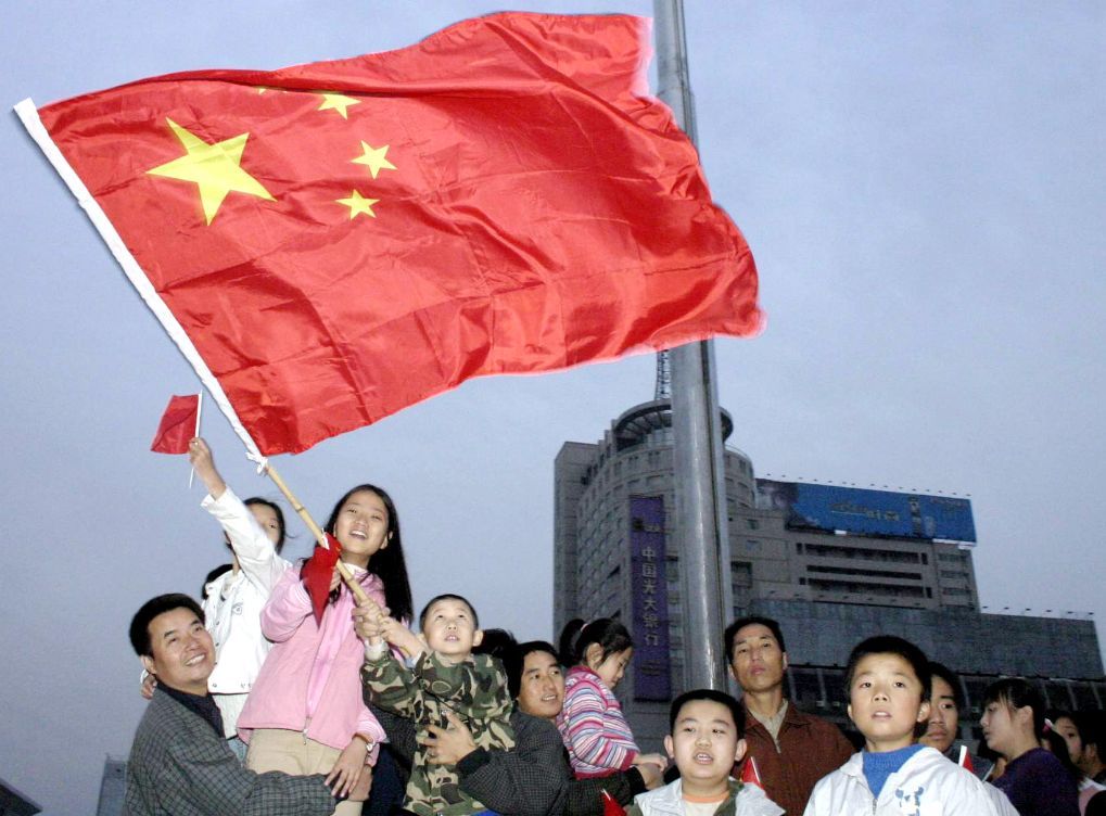 2004年10月1日清晨,在陕西西安新城广场上,孩子们挥舞着一面五星红旗欢庆节日。当日,在西安新城广场上举行了隆重的升旗仪式,上万名群众早早前来观看,表达对祖国的祝福。新华社记者 陈钢 摄