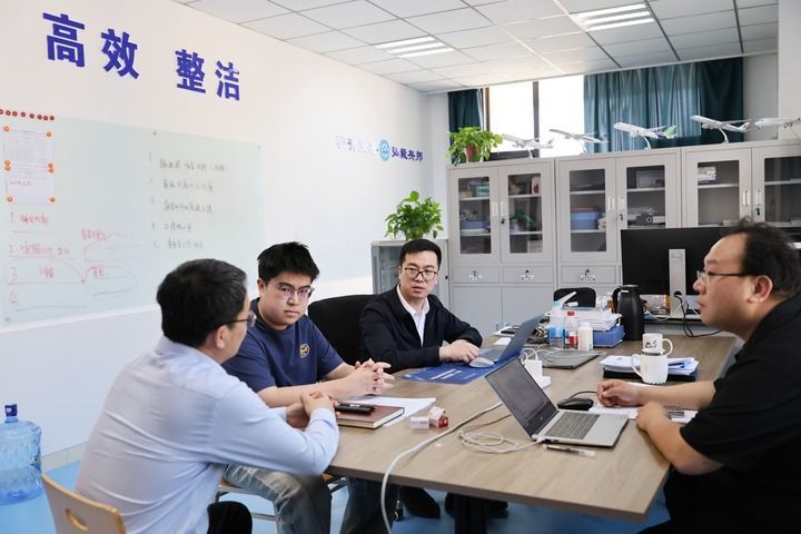 中国民航大学“远航青年突击队”的史磊（右二）、孙凤鸣（左一）、张雪洋（右一）在办公室和学生交流（4月30日摄）。