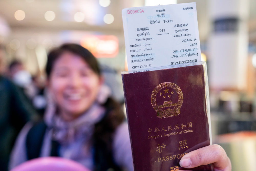 2024年2月14日，在云南昆明乘坐中老铁路国际旅客列车前往老挝的游客展示购买到的车票。中老铁路通车后，不少游客选择乘坐国际旅客列车跨境旅行，推动老挝沿线旅游业发展。