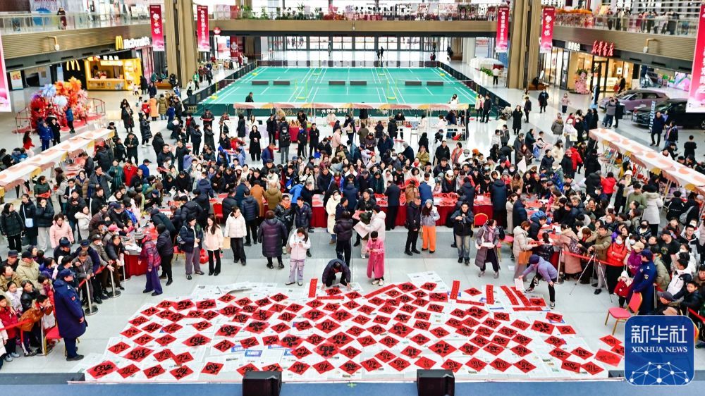 ↑ 1月22日，文艺工作者在天津市滨海文化中心为市民现场书写春联和“福”字。新华社发（杜鹏辉摄）