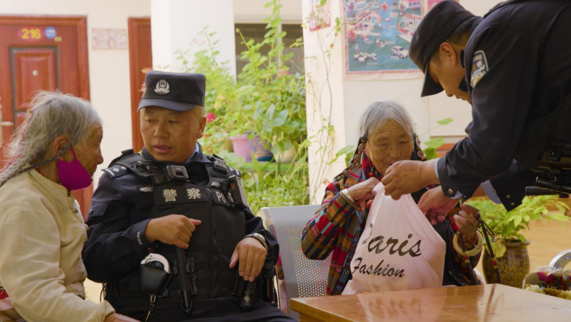 图为索县大连新村便民警务站民警嘎玛占堆,在供养中心看望老人。