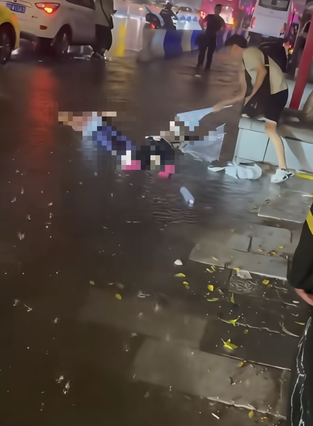 事发现场,一名男子试图用雨伞救援。