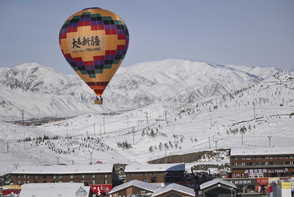 游客在新疆阿勒泰将军山国际滑雪度假区乘坐热气球赏雪景。新华社记者 胡虎虎 摄