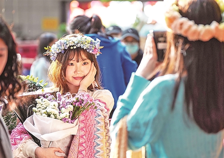 游客在云南昆明斗南花卉市场拍照。新华社发