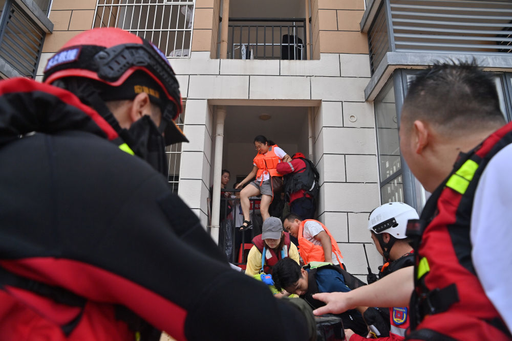↑ 7月8日,救援人员在广西贵港市西江教育园区转移被困教师。
