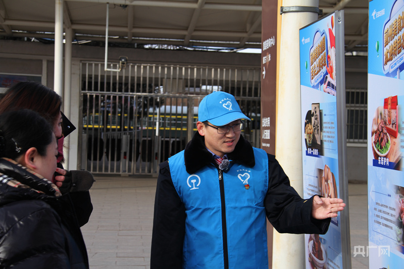 蓟州北站客运员白静为出站旅客介绍蓟州特色美食购买点（央广网发 肖亦杰 摄）