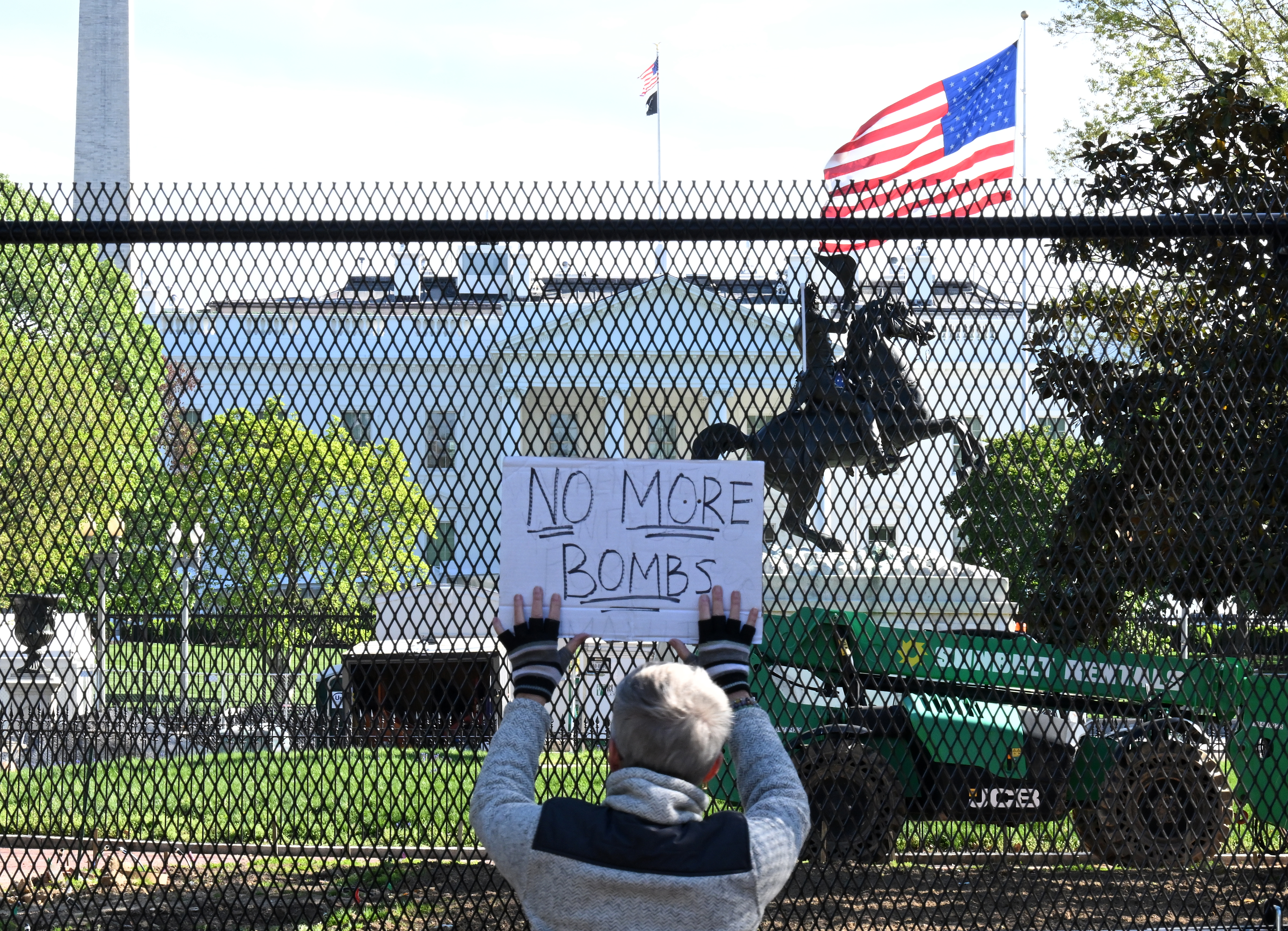 4月7日,一名示威者在美国首都华盛顿的白宫前手举标语。新华社记者李睿摄