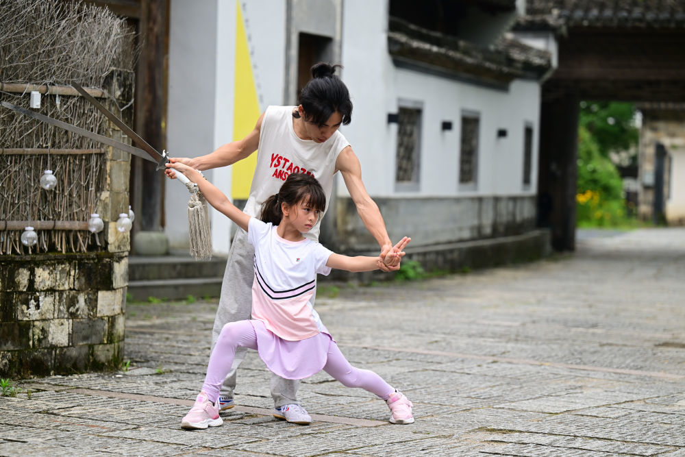 5月30日,在“阿琳娜花园”民宿内,阿琳娜(前)在师傅指导下练习武术。 新华社记者 周牧 摄
