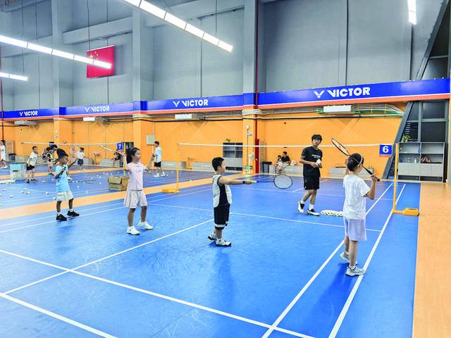 孩子们在教练指导下学习打羽毛球。