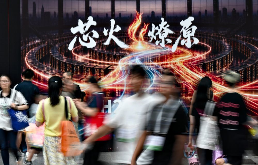 2026年7月20日,2026世界人工智能大会暨人工智能全球治理高级别会议在上海闭幕,参观者从写着“芯火燎原”的广告牌前经过。新华社记者 黄晓勇 摄