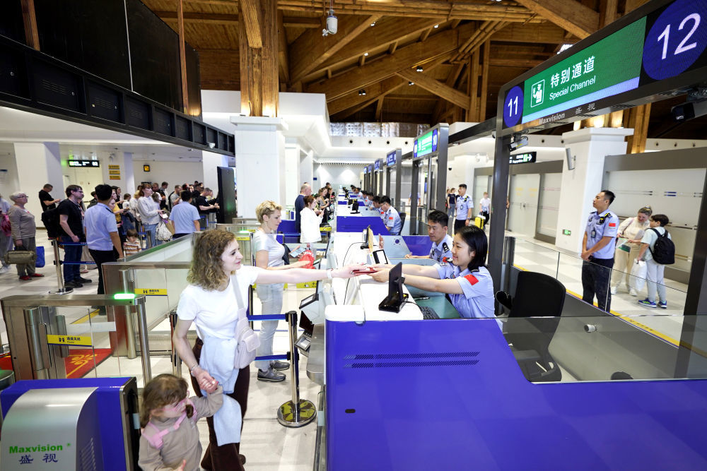 3月27日,海南凤凰边检站执勤民警为入境旅客办理边检手续。新华社发(蒙绪顺 摄)