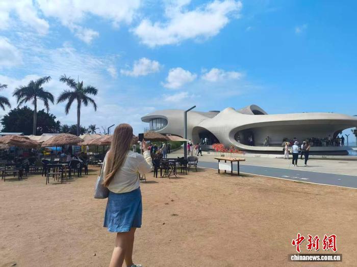 俄罗斯姑娘爱丽在海口云洞图书馆前拍摄，并用俄语介绍眼前的美景。　中新网记者 张茜翼 摄