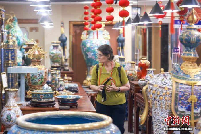 9月30日,外国游客在北京市珐琅厂参观景泰蓝工艺品。第十四届景泰蓝老物件淘宝大集正在北京市珐琅厂举行,大集深耕传统非遗文化,创新消费体验,不但汇聚诸多20世纪60至80年代出口创汇景泰蓝实物,还汇集料器、玉雕、石画等传统工艺美术,以及老陈醋等老字号特色展销摊位。 中新社记者 贾天勇 摄