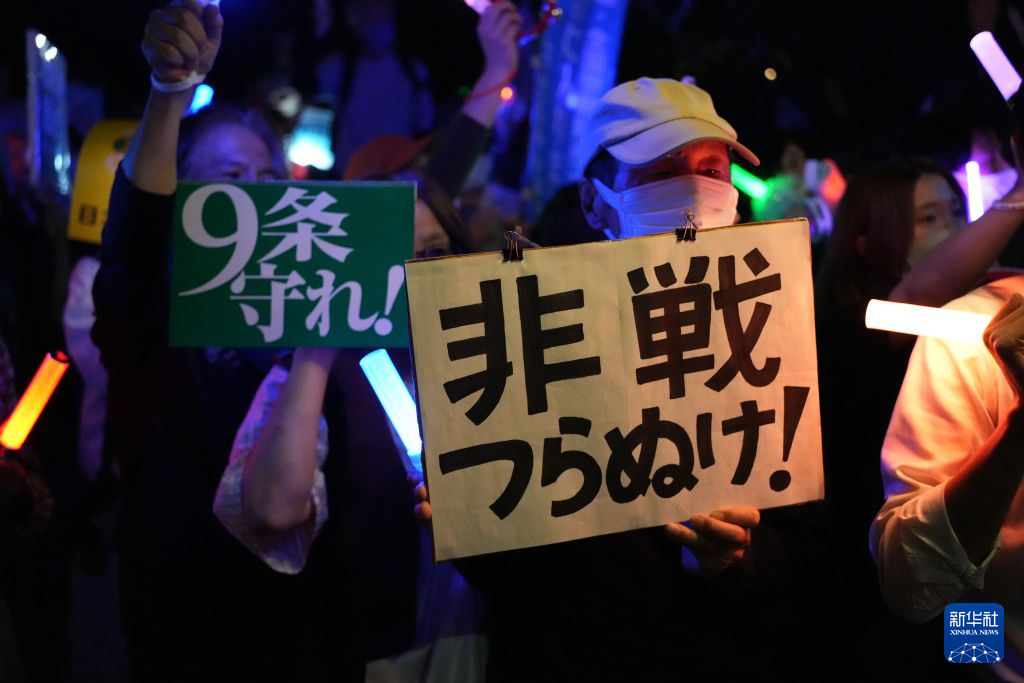 10月19日晚,在位于日本东京的日本国会前,民众手持标语参加抗议集会。新华社记者 梁晨 摄