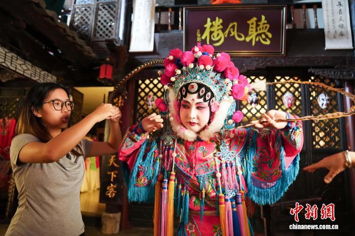 8月13日,云南昆明牛街庄滇戏博物馆工作人员指导游客拍摄照片。中新社记者 刘冉阳 摄