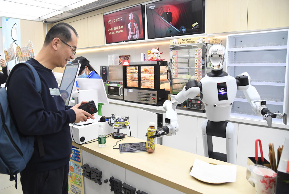 4月22日,在北京市海淀区中关村大街一座大厦内的便利店,机器人将抓取好的饮料交给顾客。新华社记者 任超 摄