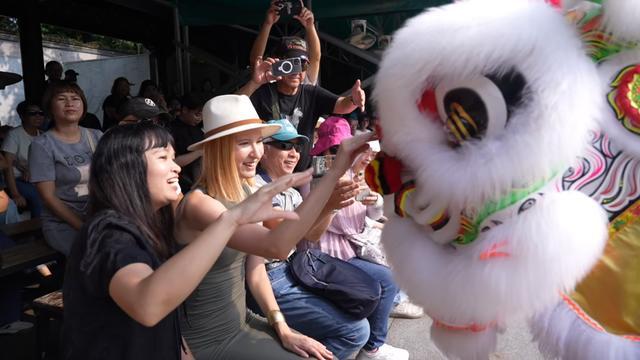 俄罗斯旅游博主环环与佛山祖庙醒狮表演互动。
