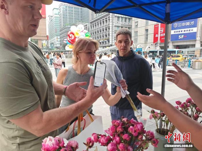 图为俄罗斯游客购买芍药鲜切花。徐白村 供图