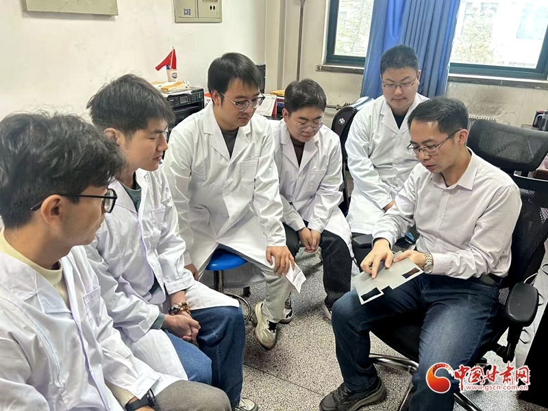彭鹏(右一)与学生在研讨酒钢新一代锌铝镁产品