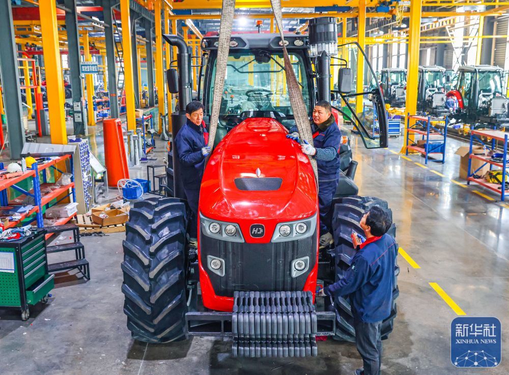 ↑ 1月5日，在位于江苏省扬州市的金世纪（江苏）智能科技有限公司，工人在大马力全动力换挡智能拖拉机生产线上作业。新华社发（任飞摄）