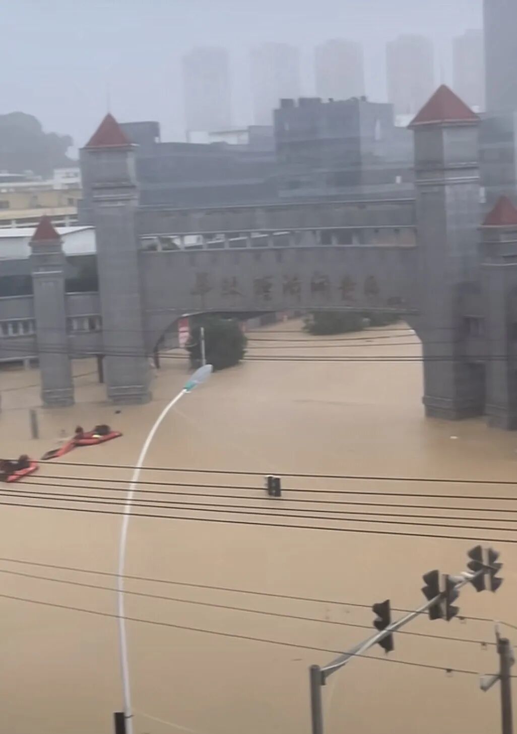 华林经济开发区门口,洪水已漫过园区招牌大半,几艘救援艇正在作业 / 视频截图