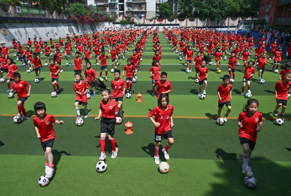 2025年5月19日,在重庆市大田湾小学,同学们参加足球大课间活动。新华社记者 陈诚 摄