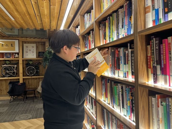 2月3日深夜，宣南书店（法源寺店）里，夜间管理员程泽鑫正在整理书架。新华每日电讯记者宋依黛 摄