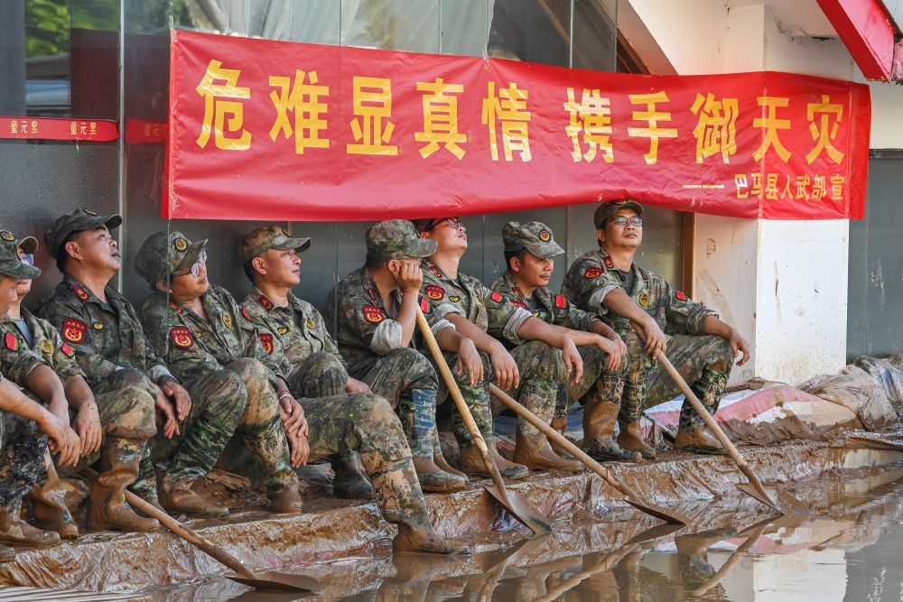 ↑ 7月10日,在广西贵港市,从外地前来支援的救灾人员在清淤间隙就地休息。