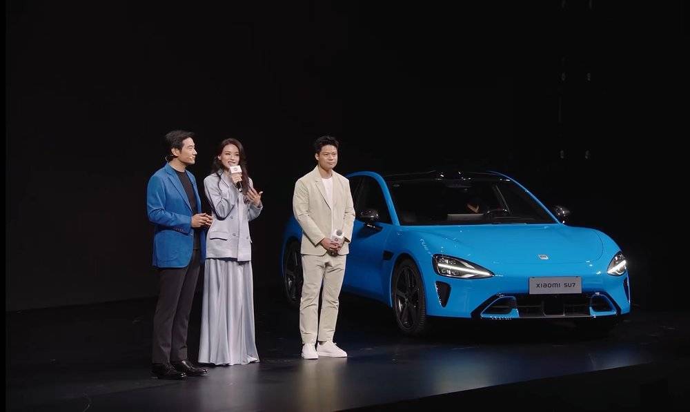 在发布会上，雷军、舒淇、苏炳添站在新款小米SU7旁边；图源：小米发布会