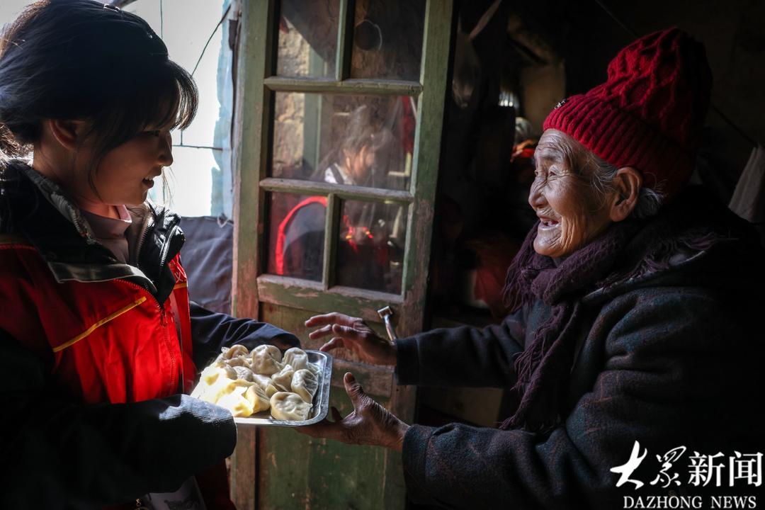 9岁的小志愿者刘梓瑜为88岁的李元花送来饺子。