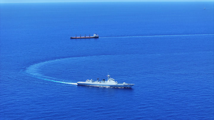 中国海军第46批护航编队焦作舰(下)护送货船至解护点后与之分航(2024年5月7日摄)。新华社发(张大禹 摄)