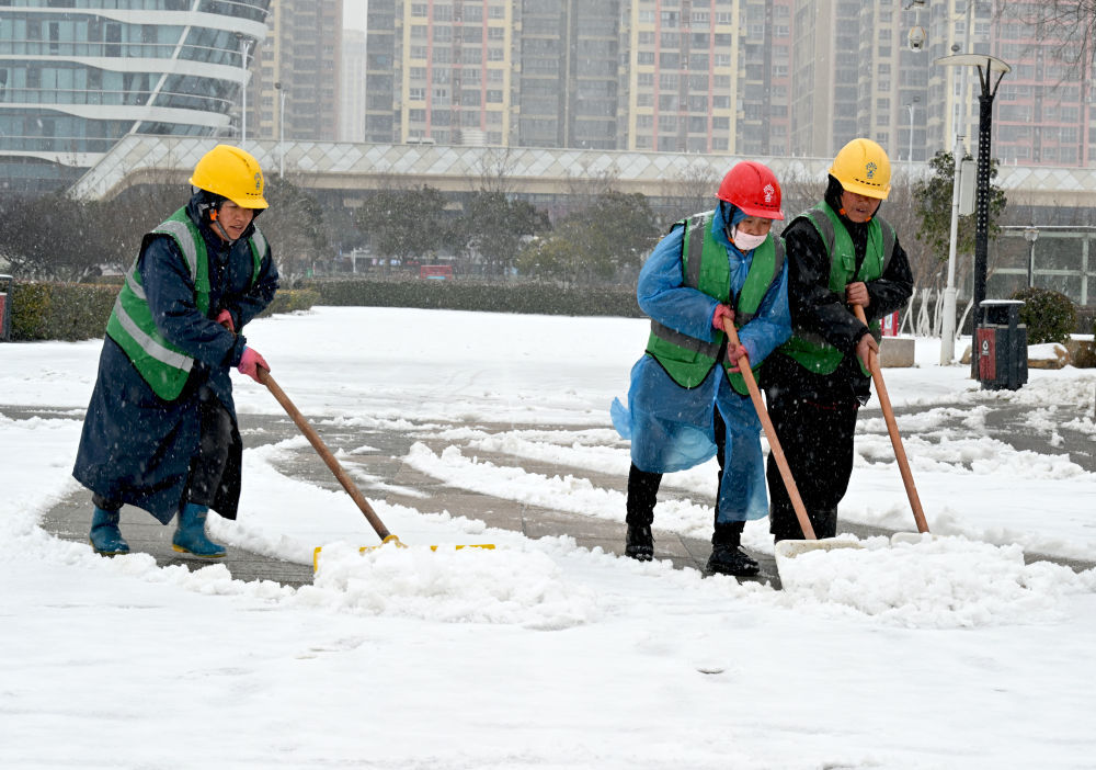 1月19日，在安徽省亳州高新区市政公园，园林工人在清理路面积雪。新华社发（刘勤利摄）