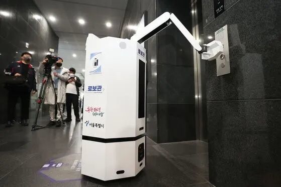 图:首尔市厅的机器人公务员正在按电梯(韩联社)