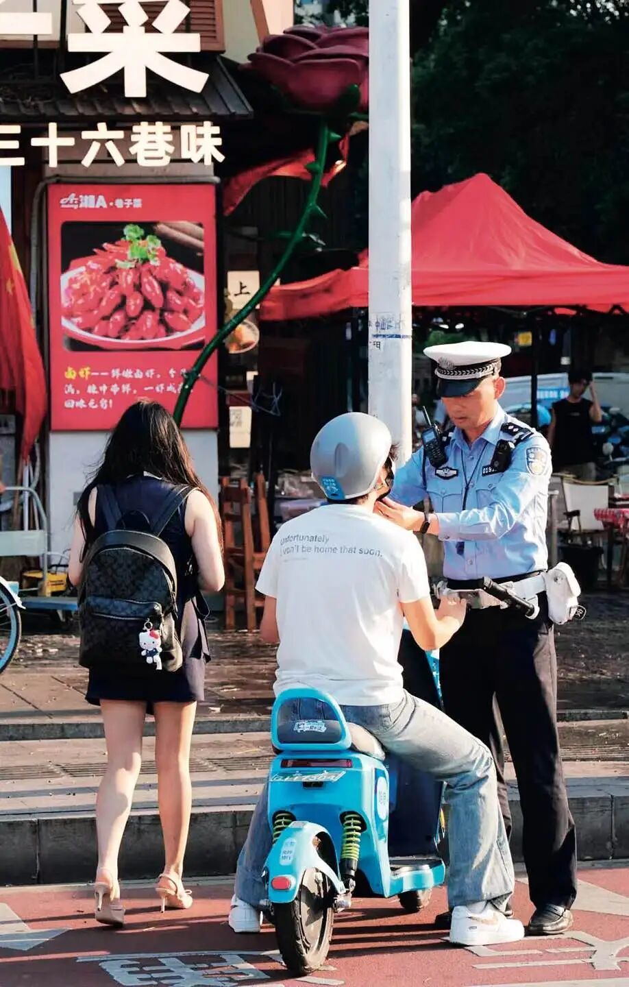 长沙交警帮骑行者系好安全带。