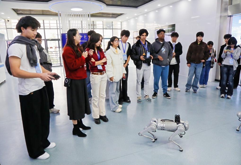美国“飞虎队友谊学校”代表团学生体验操控四足机器人（2025年12月26日摄）。新华社发（广西壮族自治区外事办供图）