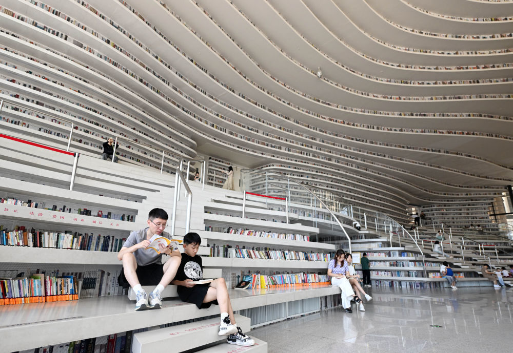2024年8月27日，市民在天津滨海新区图书馆内阅读。有着“滨海之眼”之称的滨海新区图书馆位于天津滨海文化中心，目前已成为天津滨海新区的文化“新地标”。