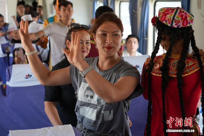 游客在慢火车上共舞。努尔古再丽 摄