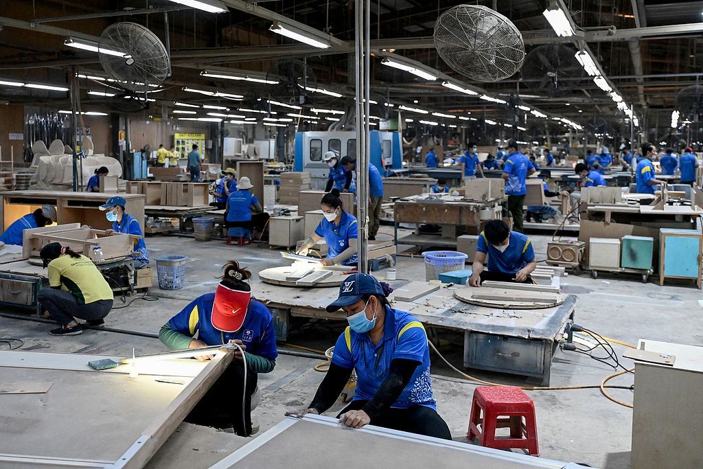 越南胡志明市一家家具厂内,工人在组装家具。 (视觉中国)