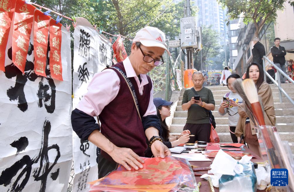 2月13日,在香港楼梯街,萧嘉豪在挥春档忙碌。新华社记者 陈铎 摄