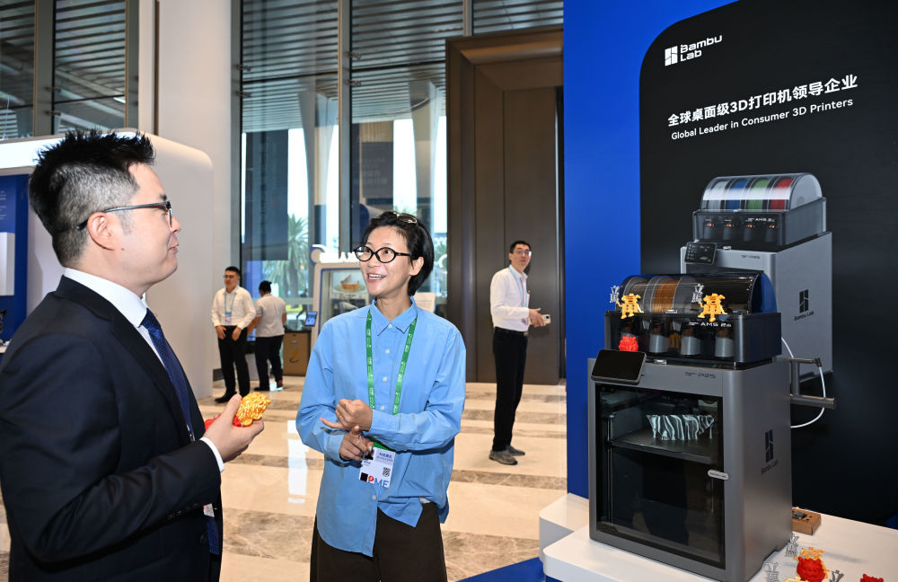 9月5日，工作人员（右）向参观者介绍拓竹3D打印机。新华社记者 邓华 摄