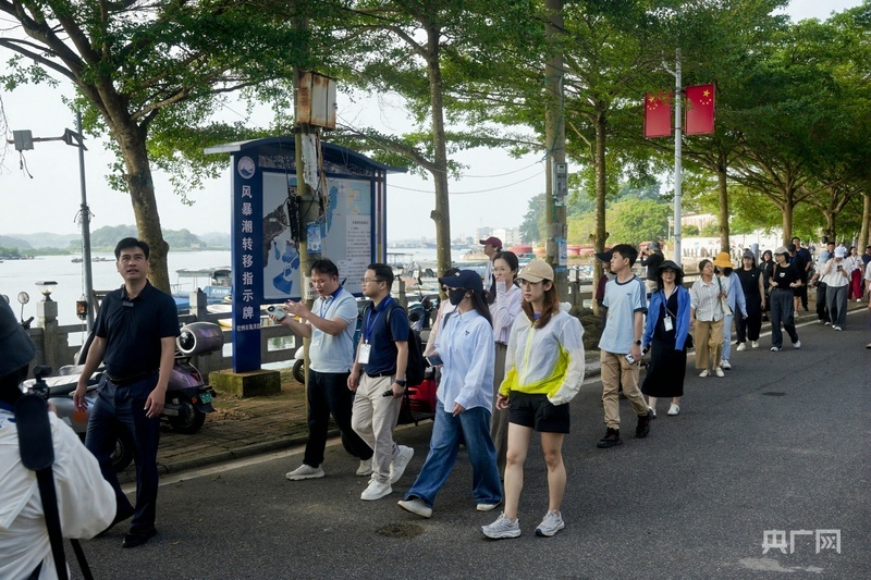 游客沿龙门港海岸线漫步，感受渔村新貌（央广网记者 滕艳娇 摄）