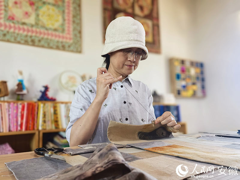 工作台前,章慧手工缝纫。人民网记者 汪瑞华摄