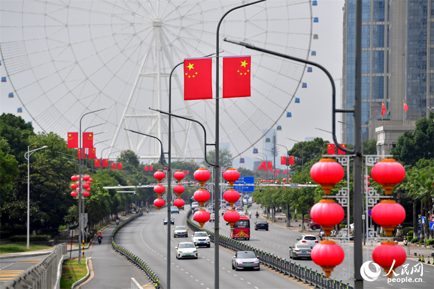 南昌市红谷滩区的道路两侧悬挂着崭新的国旗，城市洋溢着喜庆祥和的节日氛围。人民网记者 时雨摄