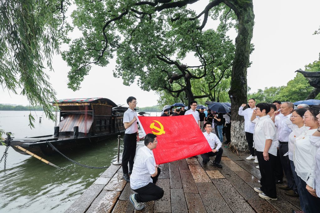 6月30日，嘉兴市南湖区南湖街道南湖社区党委与上海市黄浦区淮海中路街道新天地居民区党总支的党员代表，共同开展主题党日活动，在嘉兴南湖红船旁重温入党誓词。新华社记者 徐昱 摄